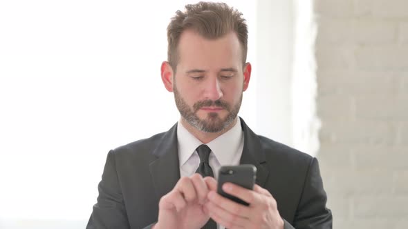 Young Businessman Browsing Internet on Smartphone