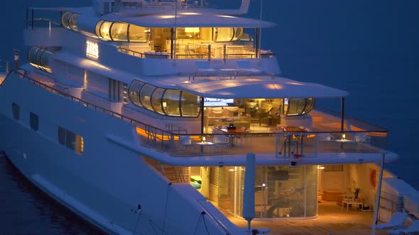 A luxury yacht anchored at night in a resort town in Italy, Europe.