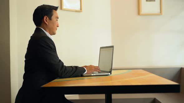 Businessman using laptop at table 4k