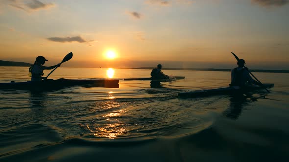 Sunset River and Boaters Rowing Along It