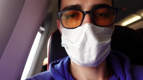 Selfie of a Man in Medical Mask Sitting in a Airplane and Waiting for the Flight