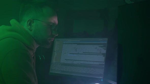 A Caucasian Man in Glasses Works on the Computer Inputs Code Types Very Fast on the Keyboard Checks
