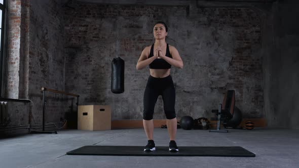 Young Indian fitness woman doing squat in the gym