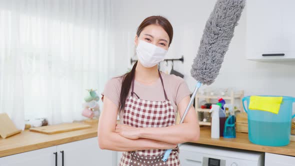 Portrait of Asian young cleaning service woman worker wear mask working in house and look at camera.