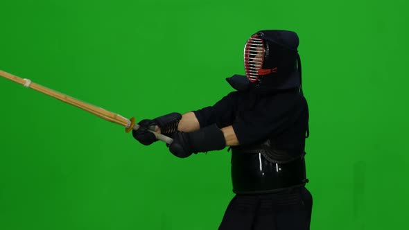 Masculine Kendo Warrior Practicing Martial Art with the Bamboo Bokken on Green Screen. CLose Up