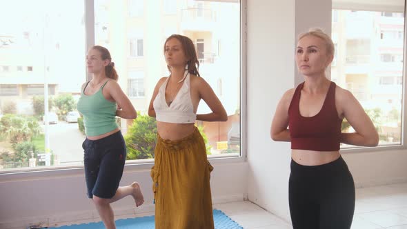 Three Women Having Yoga Classes in the Studio  Balancing on One Leg