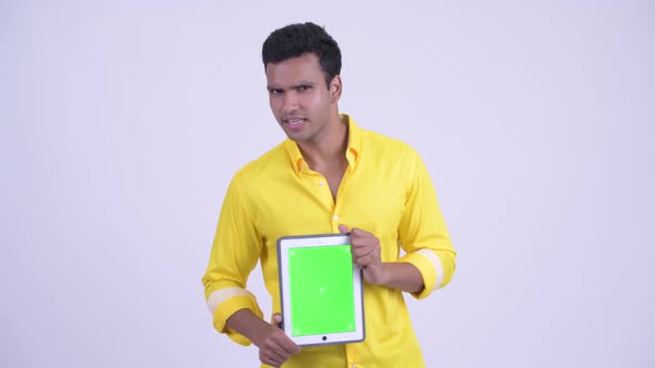 Happy Young Indian Businessman Talking While Showing Digital Tablet