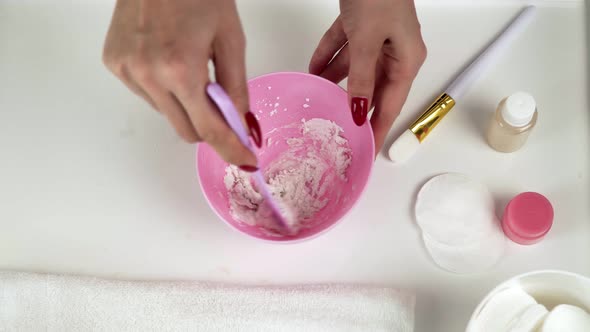 Close Up of Professional Beautician Makes a White Clay Mask She Mixes It a Pink Bowl