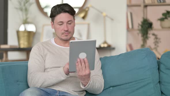 Attractive Middle Aged Man Using Tablet, at Home