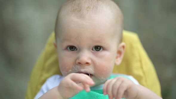 Happy Baby Boy Sitting in Highchair at Home