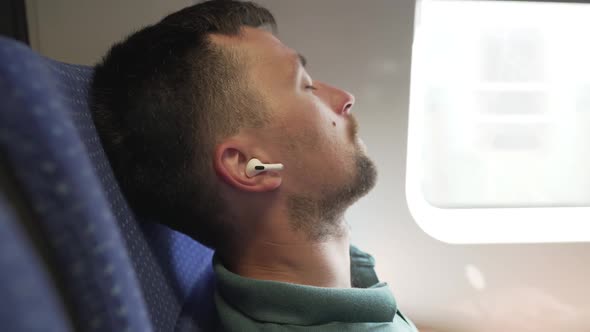 Male Tired Fell Asleep Listening to Earbuds While Traveling in Transport