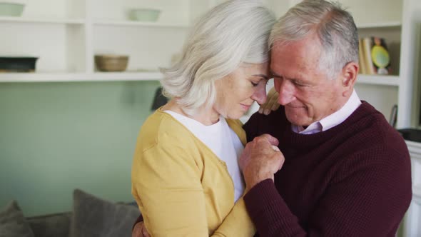 Happy senior caucasian couple embracing and slow dancing togther