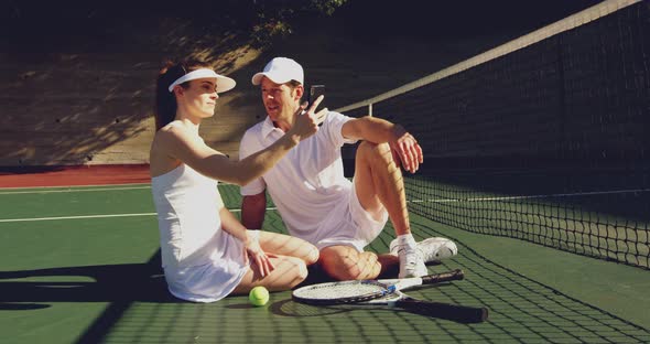 Woman and man playing tennis on a sunny day