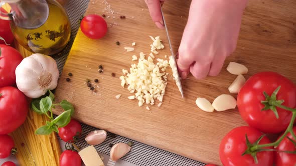Making Pasta Carbonara  Cut Garlic with Knife on a Wooden Cutting Board