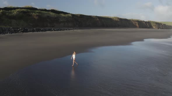 Aerial View of a woman walking on the beach, Praia do Areal, Azores, Portugal.