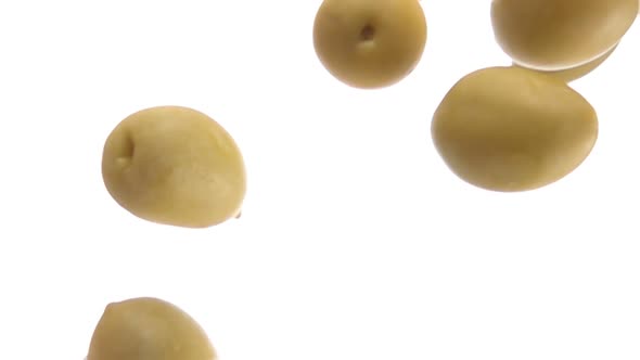 Closeup of Large Delicious Green Olives Falling Diagonally on White Background