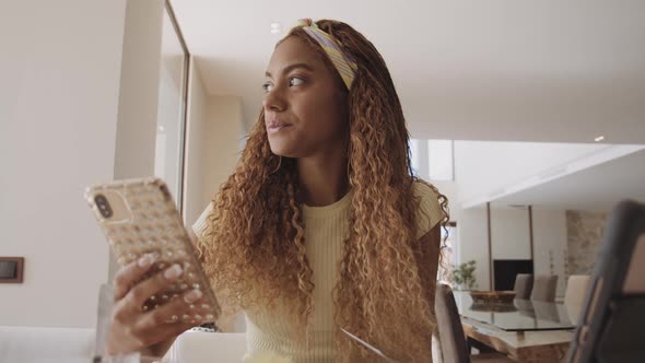 Female Student Attending an Online Class with Phone in Her Hand