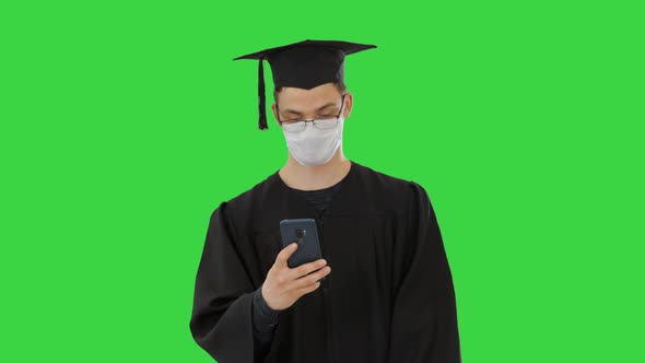 Young Raduate Student in Medical Mask Using Phone Walking on a Green Screen, Chroma Key.