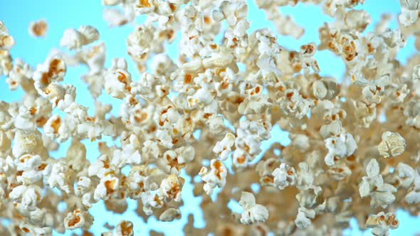 Super Slow Motion Shot of Popcorn on Blue Background After Being Exploded at 1000Fps.