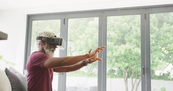 Video of african american senior man using vr headset