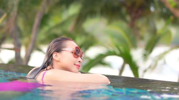 Young asian woman enjoy around outdoor swimming pool for leisure