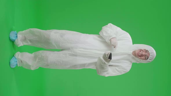 Full Body Of Man Wear Protective Uniform Ppe Use And Pointing To Mobile Phone In Green Screen Studio