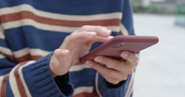 Woman play game on mobile phone at outdoor cafe