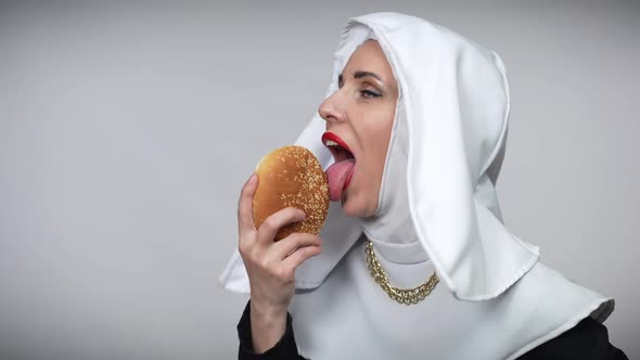 Passionate Woman in Nun Costume Licking Burger Smiling Looking at Camera