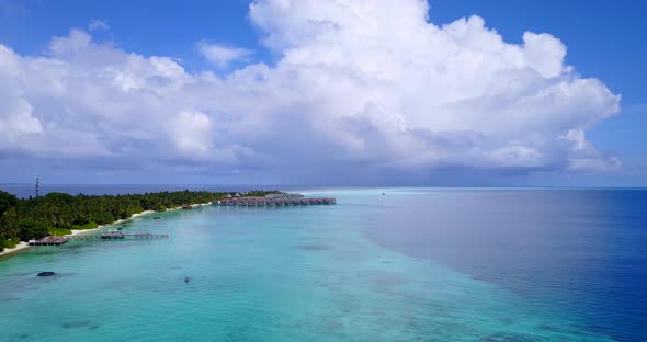 Luxury birds eye island view of a white sand paradise beach and blue sea background in colorful 4K