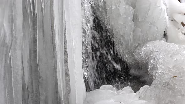 Waterfall Waters Leaping and Flowing Through Icicles in Winter