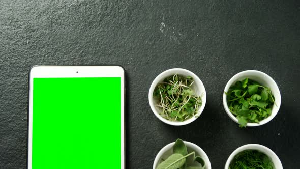 Various herbs with digital tablet on black background 4k