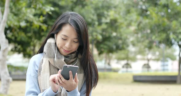 Woman talk to video call on cellphone with earphone at outdoor