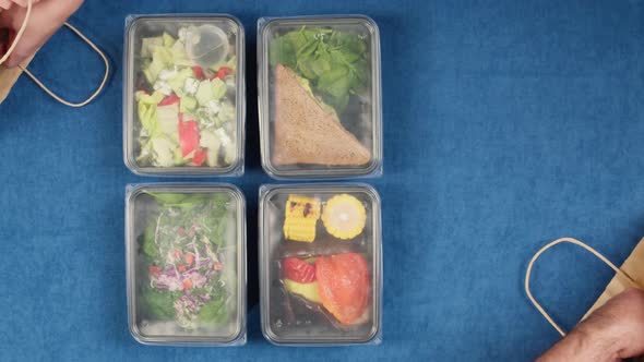 Putting Food Delivery in Disposable Containers Into Paper Bags Top View Take Away Meals Catering