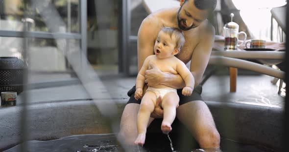 Father Bathing with His Little Baby Son at Spa Outdoors