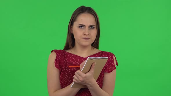 Portrait of Tender Girl in Red Dress Is Standing and Thinking, Then Happy Writing with Pencil in