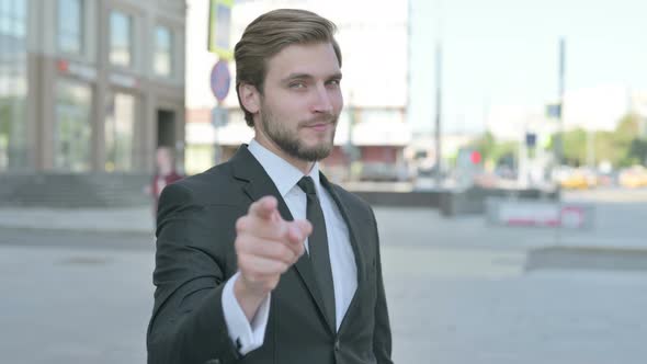 Businessman Pointing at the Camera and Inviting Outdoor