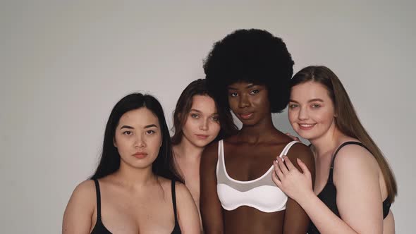 Four beautiful women wearing lingerie smiling at camera