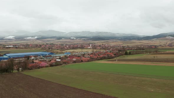 Low flyover above farmland around commune of Sancraieni in Romania