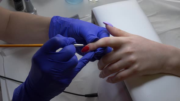manicure master applying a nail polish