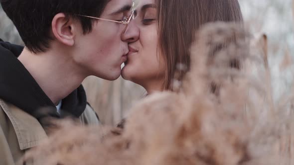 Boy in Glasses and Girl Kissing and Having Date in Reeds