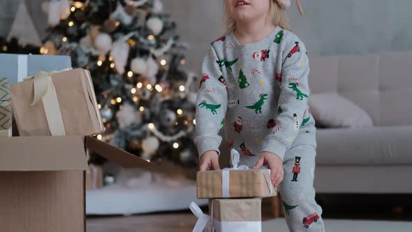 A Joyful Child Builds a Tower From All the Holiday Gifts a Little Boy Plays Before Christmas Eve