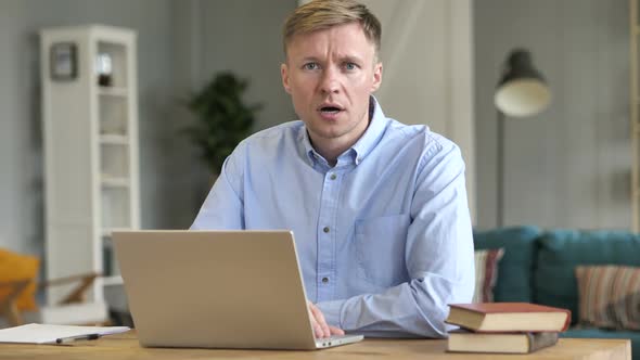 Businessman in Shock Looking at Camera While Working on Laptop