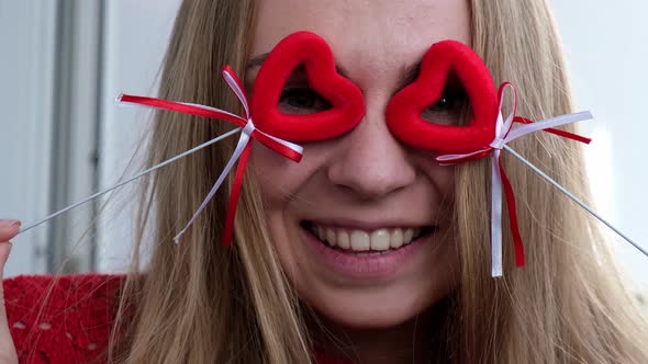 Young Blonde Girl in Red Sweater Holding Red Hearts Showing Emotions