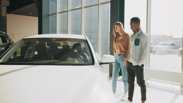 African American Man and Caucasian Woman While Walking at Modern Auto Center