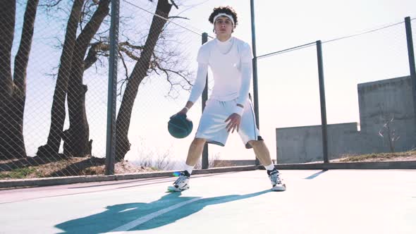 Portrait of a Basketball Player Dribbling the Ball with Skill on an Outdoor Basketball Court Slow