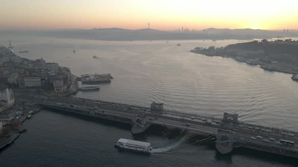 Aerial view of Galata Bridge. Boat crossing under Galata Bridge at sunrise.