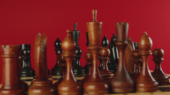 Wooden Chess Pieces on Chessboard Spinning on Red Background
