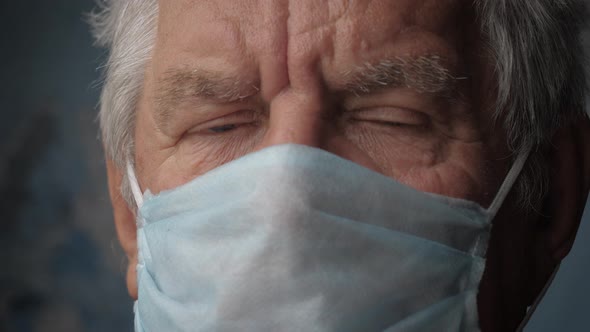 Portrait Of An Elderly Man In Protective Face Mask Looking At Camera Close Up