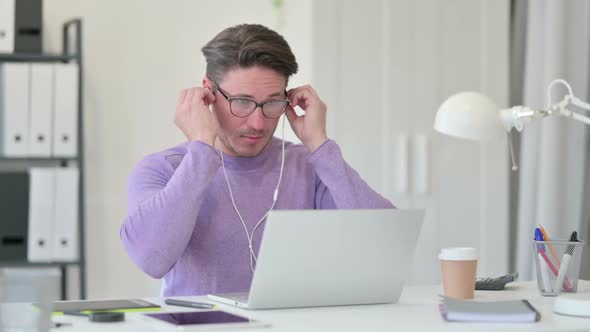 Middle Aged Man Meditating Listening Music on Laptop