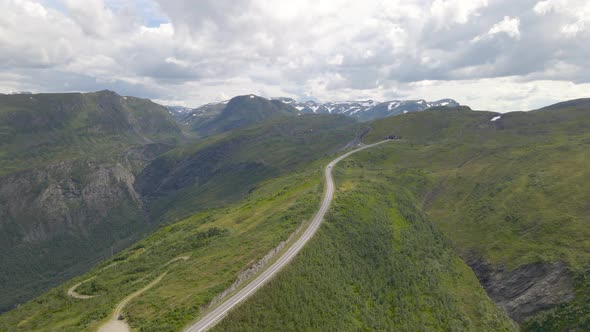 Vehicle Driving On Long Narrow Mountain Road With Cloudy Sky At Vikafjell, Norway. - Aerial Drone Sh